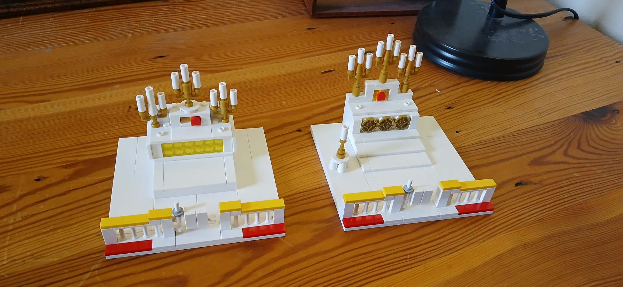 Front view of two white-and-gold brick-built altar designs
